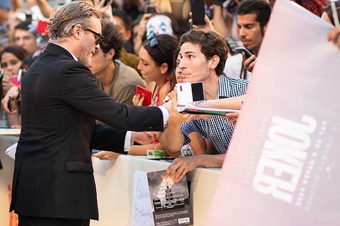 Joaquin Phoenix firmando autógrafos en la mostra de Venecia