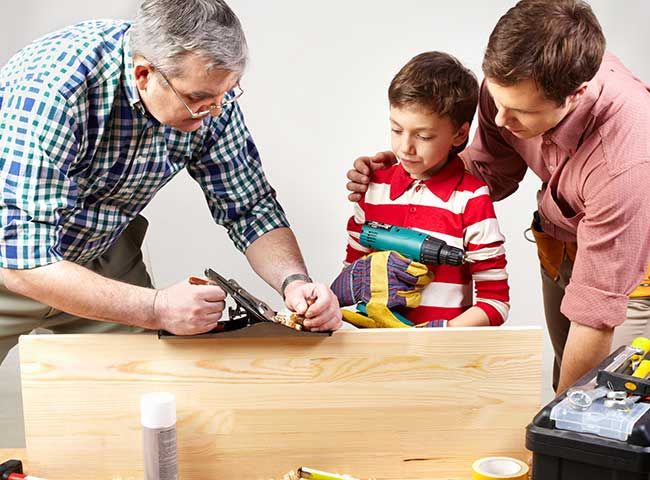 Hombre jubilado en un taller con dos chicos