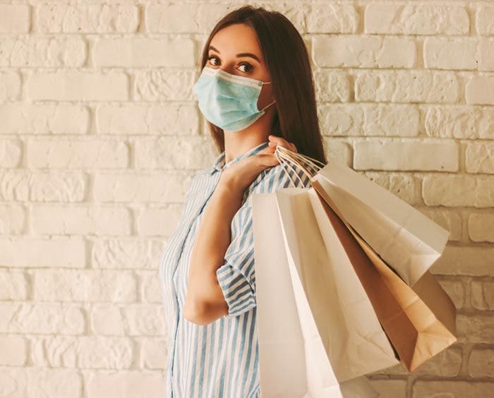 mujer con bolsas y mascarilla