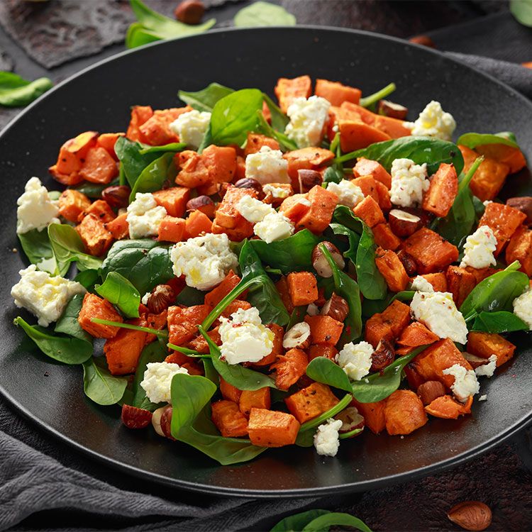 Ensalada templada de boniato con espinacas, queso feta y avellanas