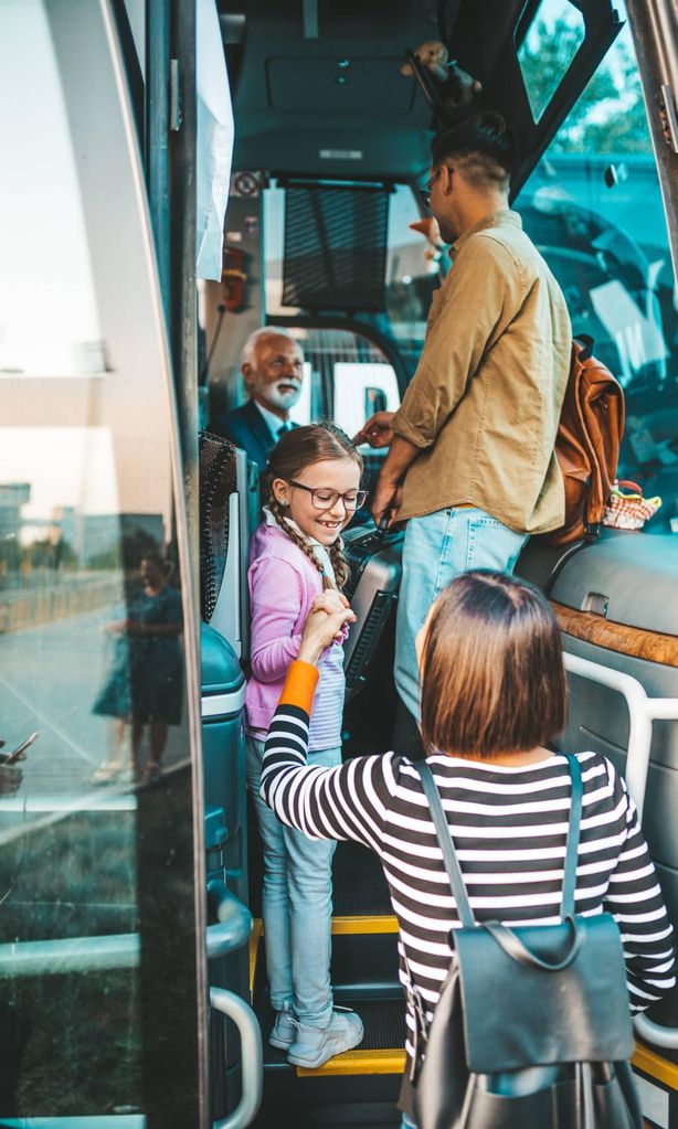 Niña con su madre subiendo a un autobus para viajar