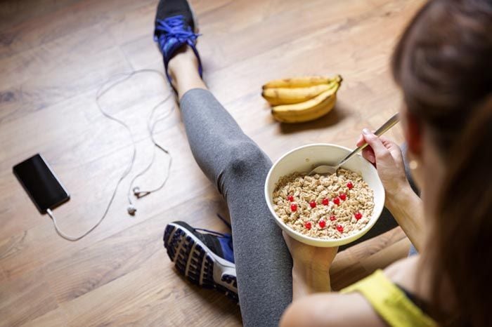 mujer vestida con ropa deportiva comiendo