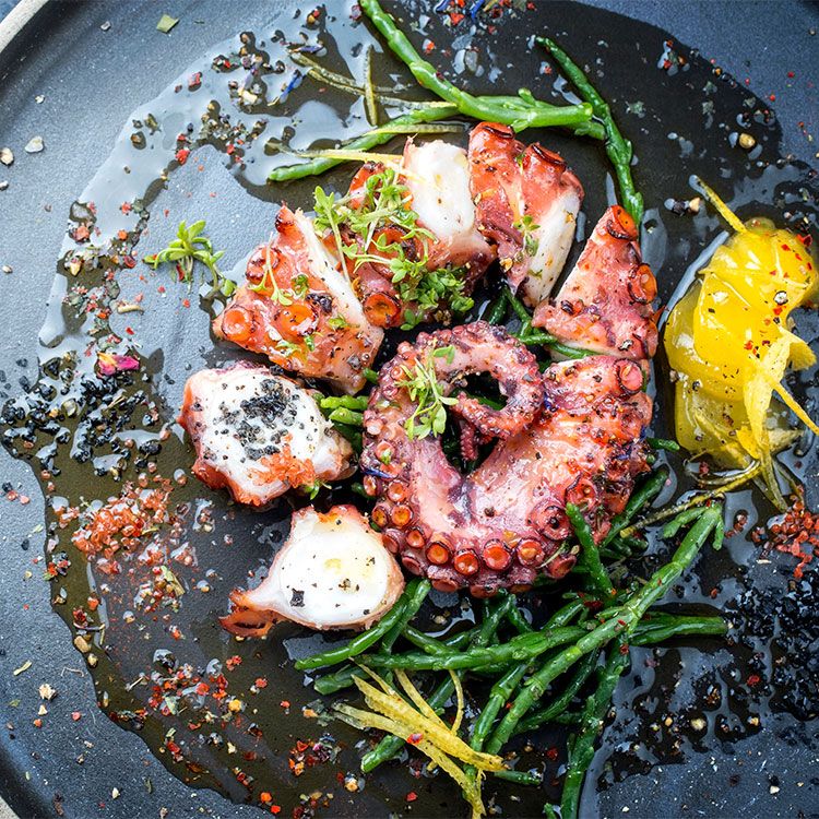 Pulpo braseado con salicornia, limón confitado y copos de chile