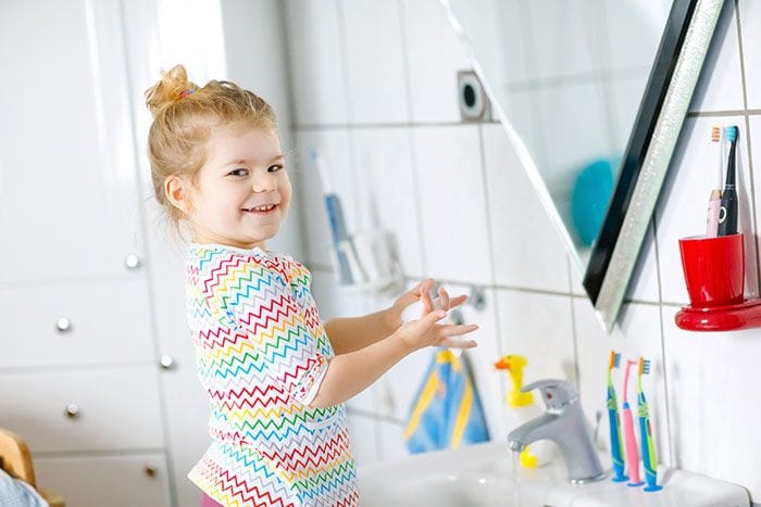 Niña frente al espejo del baño