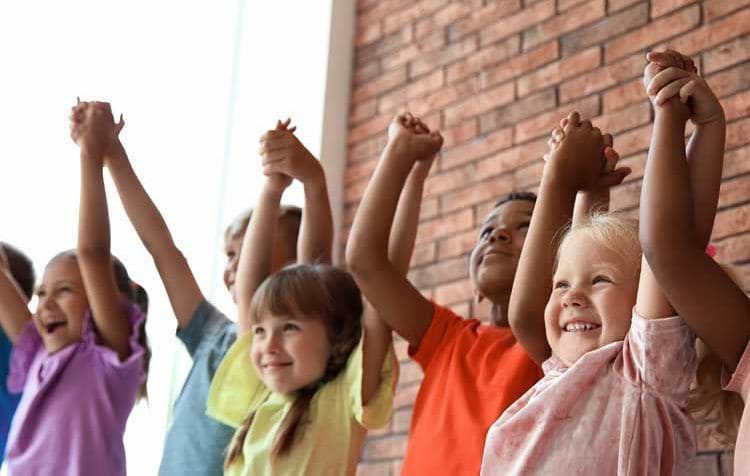 Niños cogidos de las manos sonriendo