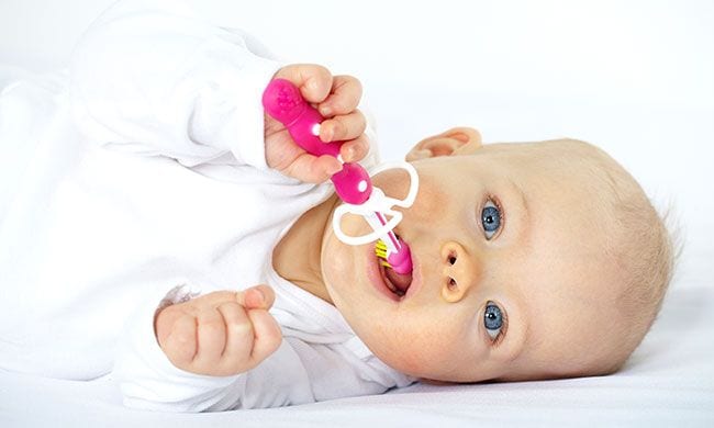 Bebe mordiendo un cepillo de dientes