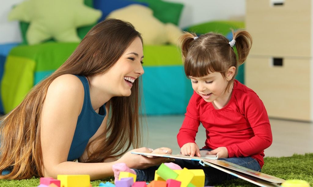 mother and toddler playing with a book