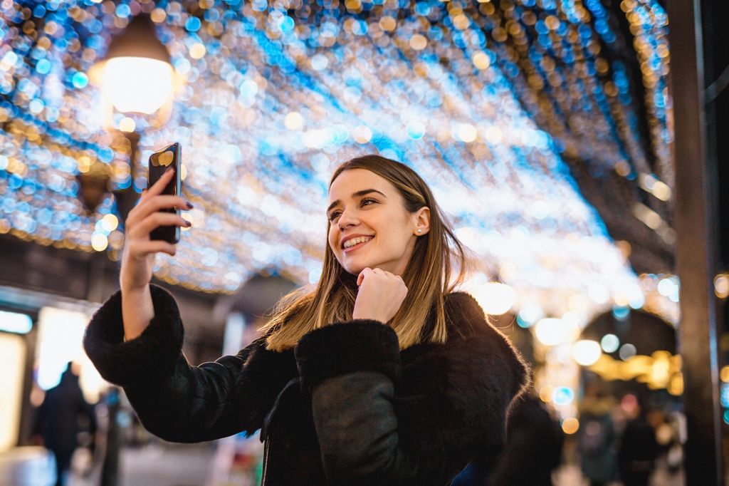 mujer en la calle en Navidad haciéndose un selfie