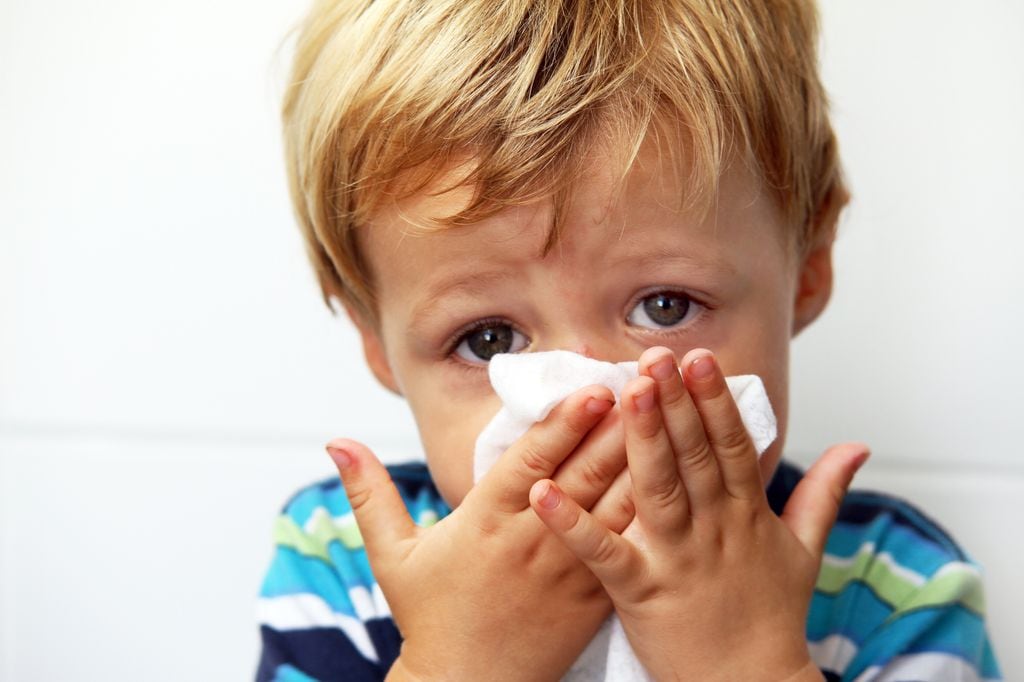 Niño sonándose la nariz