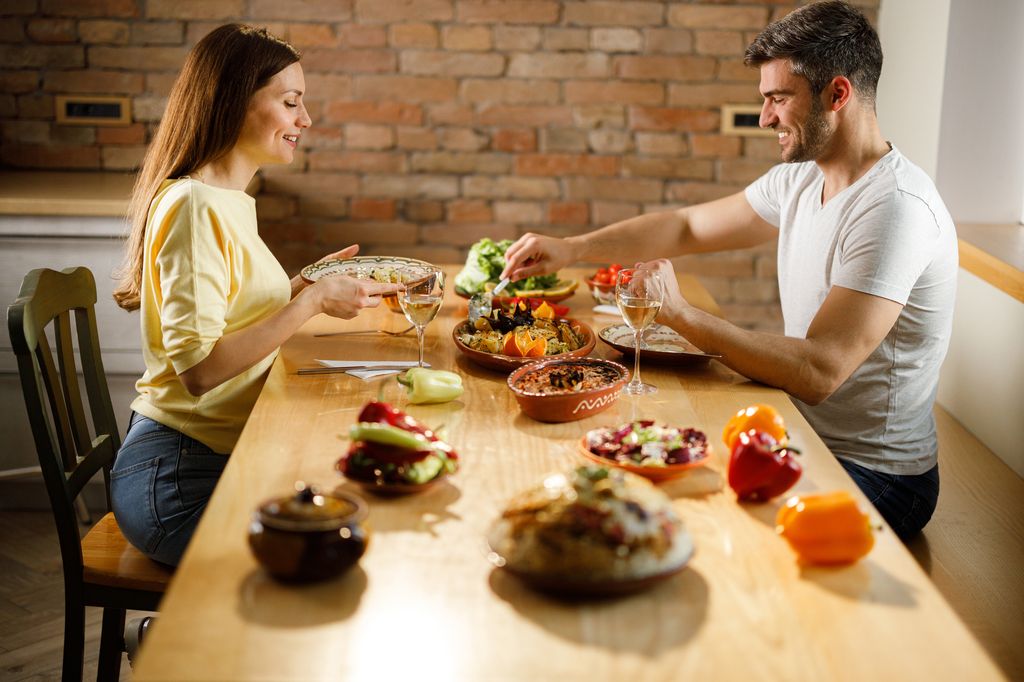 pareja comiendo de forma saludable sentados a la mesa