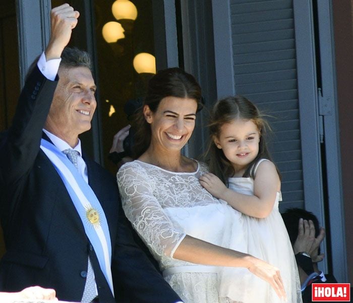 Mauricio Macri junto a Juliana y su hija Antonia saludando desde la Casa Rosada. Para ese día Juliana eligió un vestido de la firma familiar de gasa y encaje, en un tono y material similar vistió a la pequeña de la casa
