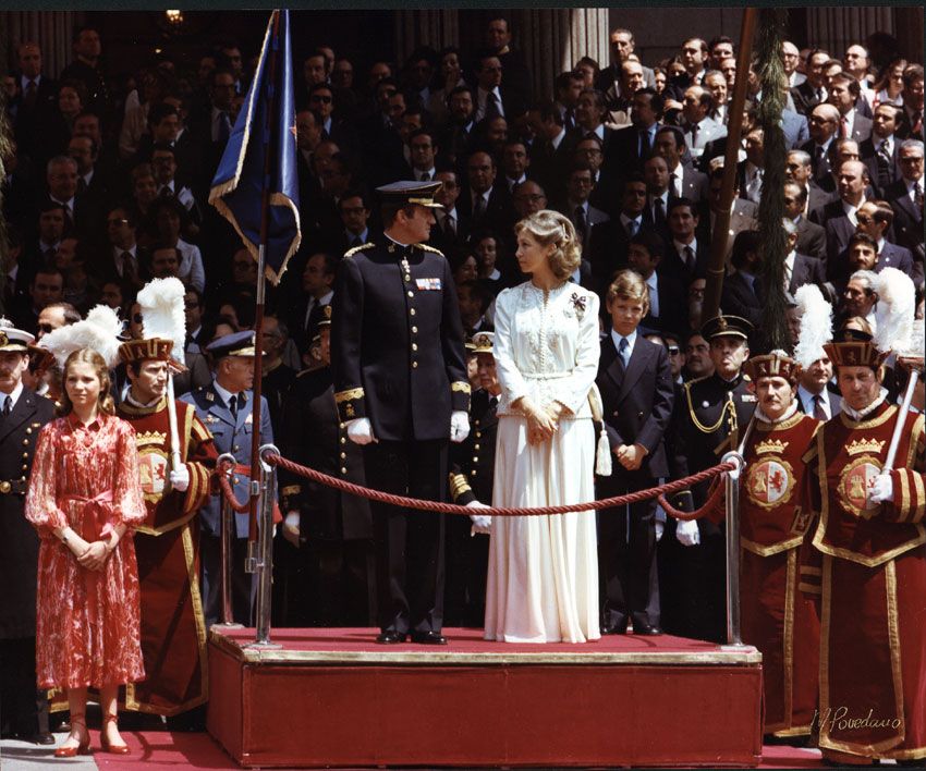 Don Juan Carlos, con uniforme de gala azul; doña Sofía, de largo con un dos piezas blanco y, como único toque de color, sus distinciones, y don Felipe, de traje y corbata para la magna ocasión, junto a la infanta Elena, que lució el mismo peinado que su hermana pequeña © Congreso de los Diputados
