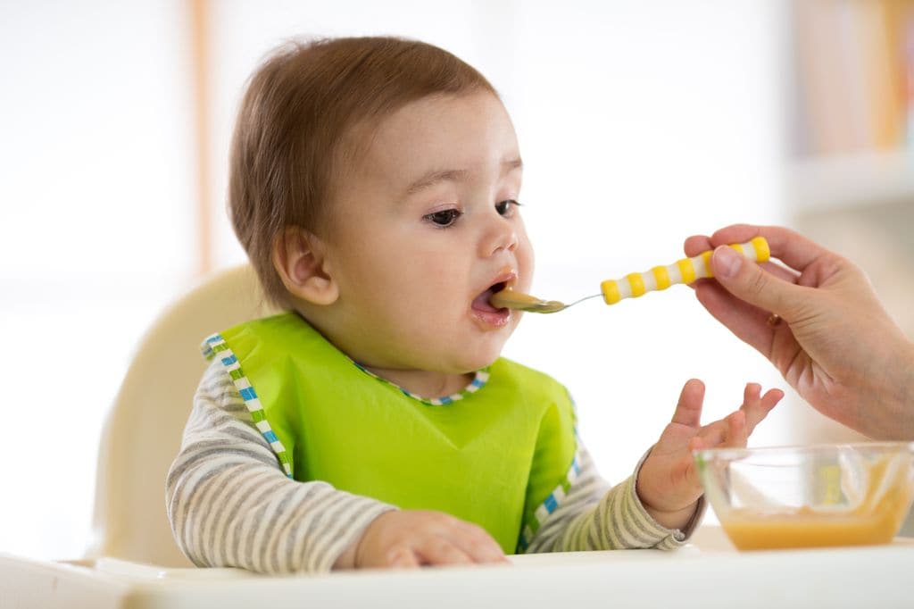 Bebé siendo alimentado con papilla