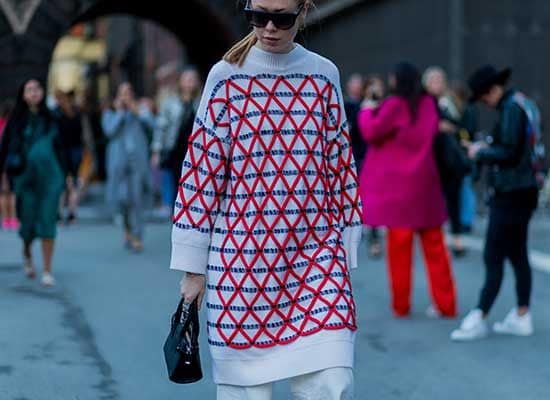 Maria Jernov luce un modelo estampado con bordados geométricos de colores, que combina con un pantalón blanco tipo palazzo. 
