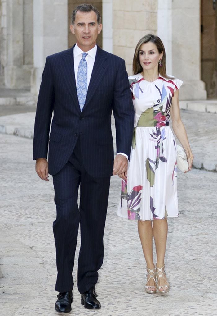 Doña Letizia eligió para esta ocasión un vestido de la colección Primavera Verano 2016 de Juan Vidalrealizado en tafeta de seda natural con motivo floral asiático y corte en cintura con falda rizada de vuelo.Era la primera vez que la Reina apostaba por una prende de este joven diseñador. Y el Rey, como siempre, traje oscuro. Eso sí, apostó por una corbata azul cielo muy orginal
