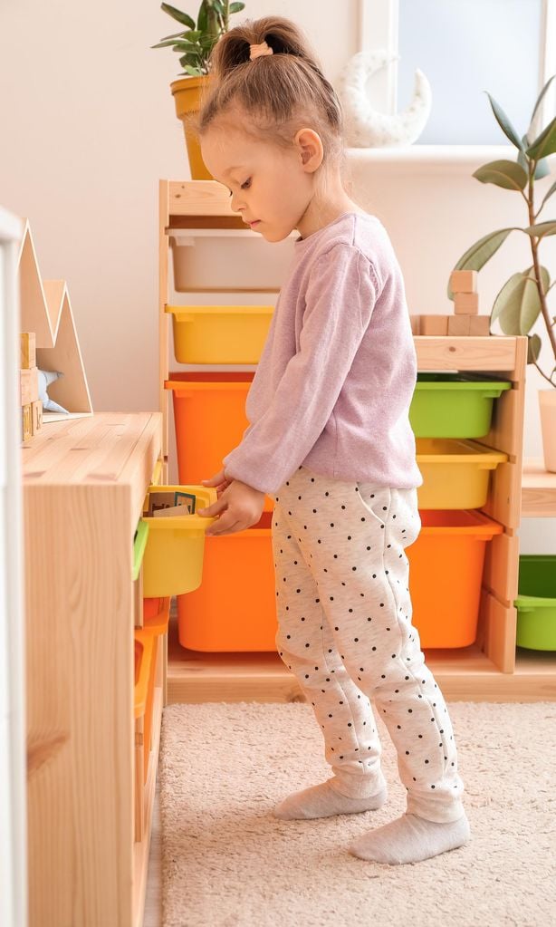 Niña recogiendo su cuarto