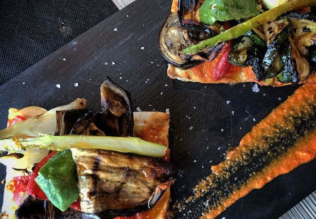 'Coca de pan de vidre' servida con verduritas braseadas. En 'Arrossería'.
