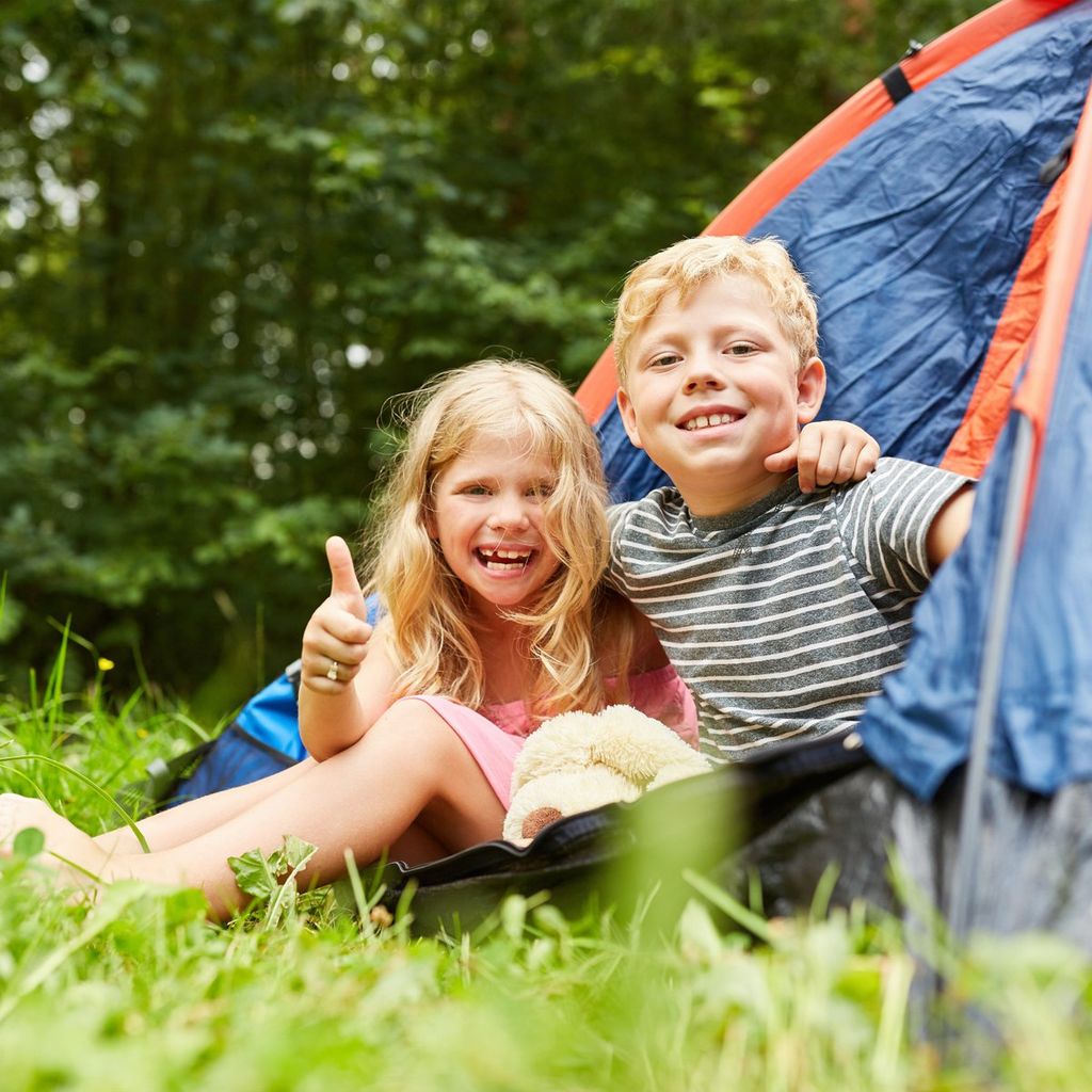 Niños en una tienda de campaña. Camping en vacaciones.