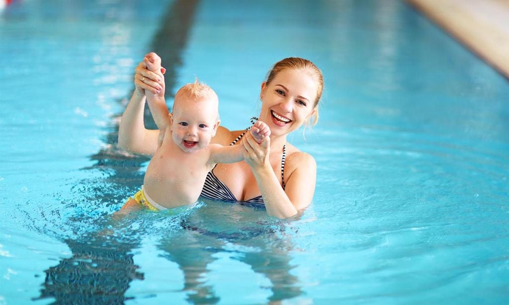 mam feliz con su beb en la piscina