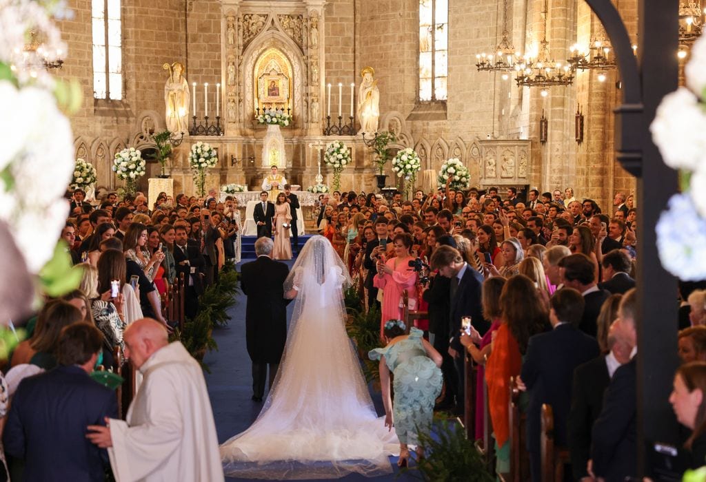 Los invitados que abarrotaban la iglesia contemplaban la entrada la novia