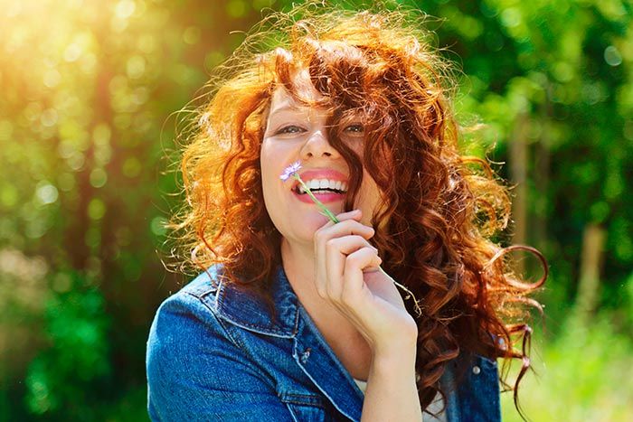 mujer feliz con una margarita