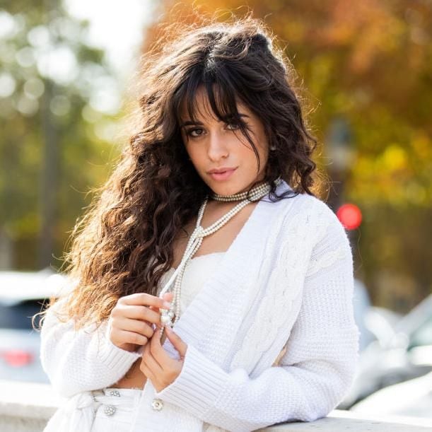 camila cabello con cabello ondulado suelto y vestido blanco