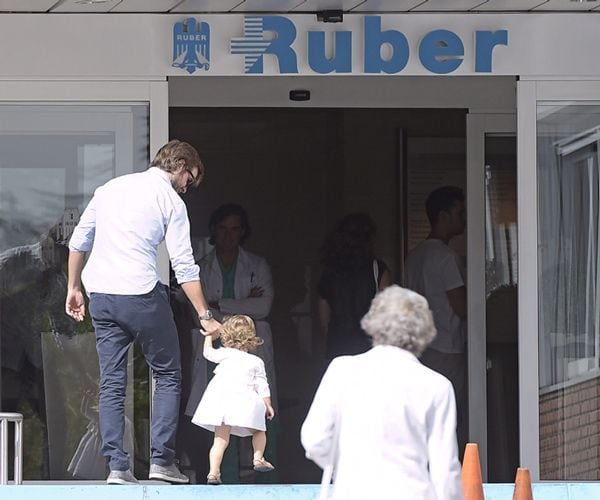 Con un precioso vestidito en tonos claros, la pequeña de 17 meses se convirtió en el centro de todas las miradas a su llegada a la clínica
