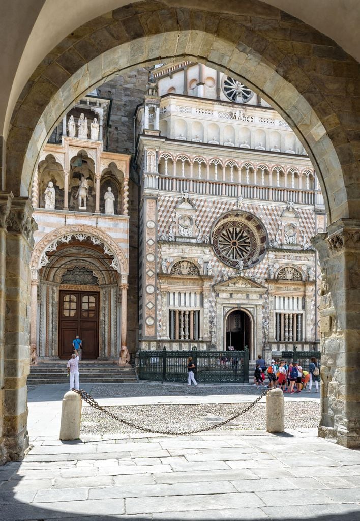 Vista de la basílica de Santa Maria Maggiore, en la ciudad alta, vista desde una de las arcadas de la Plaza del Duomo de Bérgamo