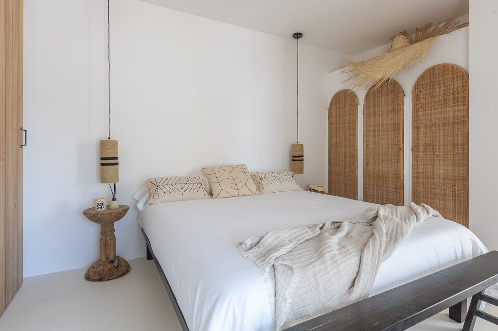 Dormitorio de estilo mediterráneo con armarios con puertas de rafia