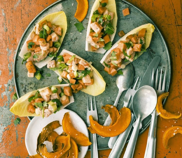 Ceviche de salmón y papaya sobre endivia con chips de calabaza