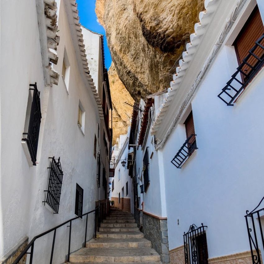 Las casas quedan agazapadas bajo rocas gigantes en este bonito pueblo blanco de la sierra de Cádiz.