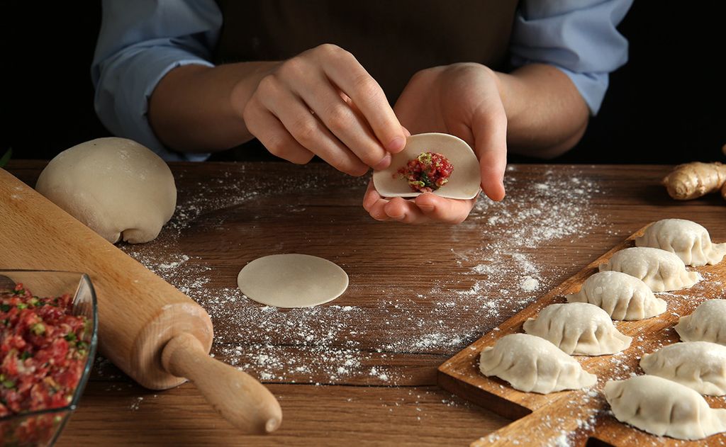 Manos rellenando 'gyozas'