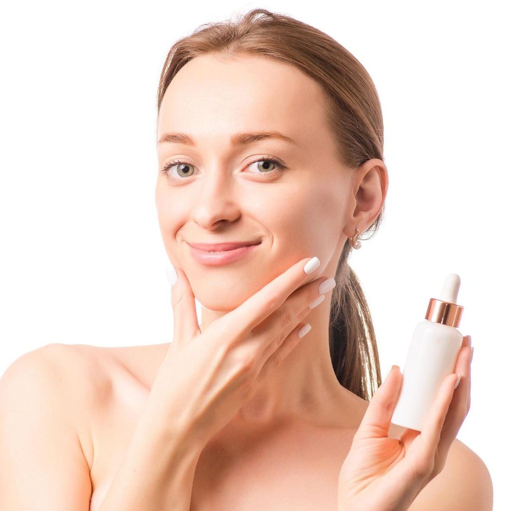 Mujer joven aplicando serum