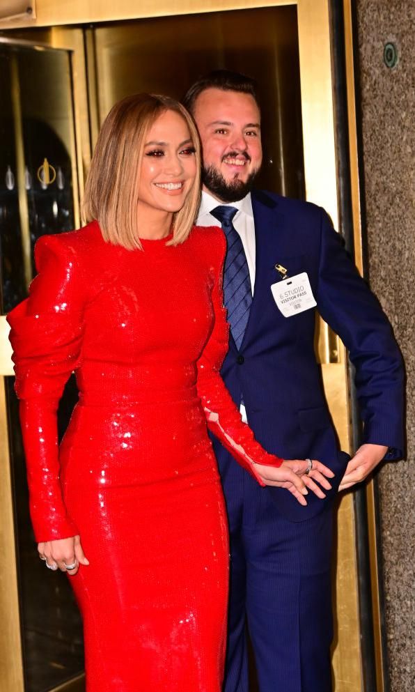 Jennifer Lopez con vestido rojo de lentejuelas junto al actor de Game of Thrones, John Bradley