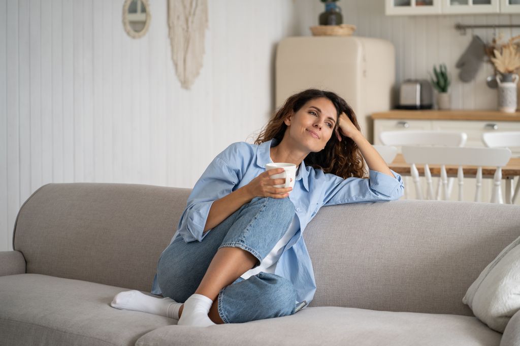 mujer relajada en el sofá tomando una infusión