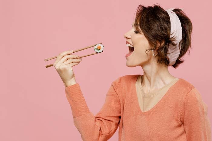 mujer comiendo sushi