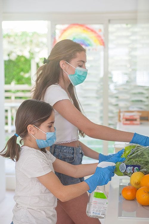 Mujer y niña colocando la compra del supermercado