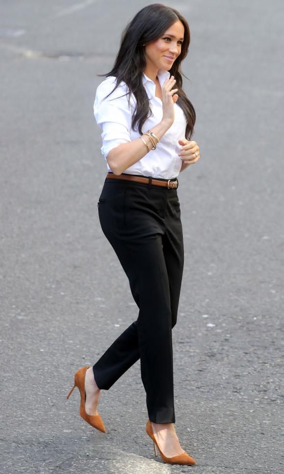 Meghan Markle con pantalón negro y camisa blanca