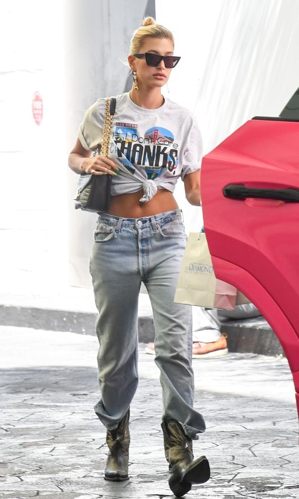 hailey bieber con pantalones abullonados sobre botas vaqueras