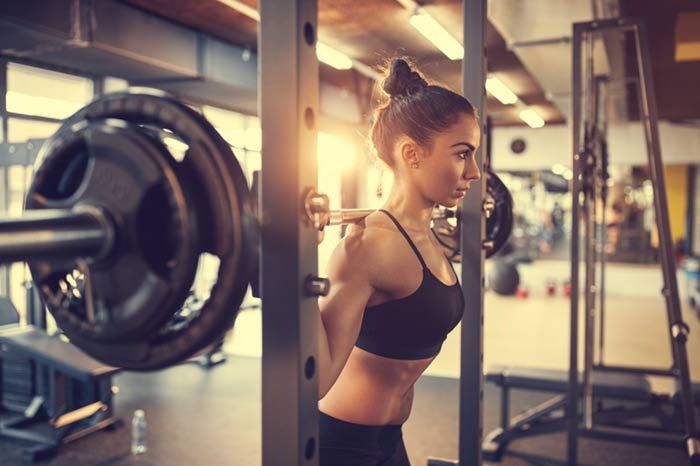 mujer levantando pesas en el gimnasio