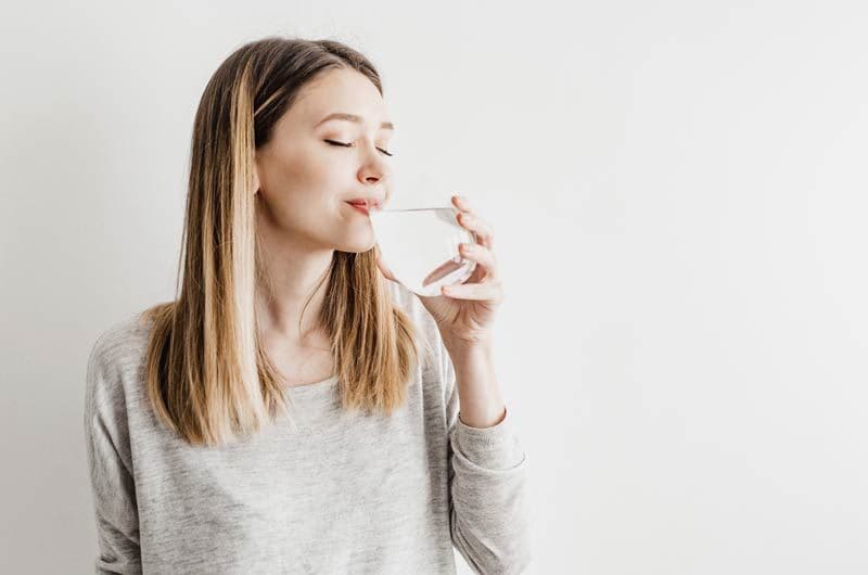 mujer bebe agua