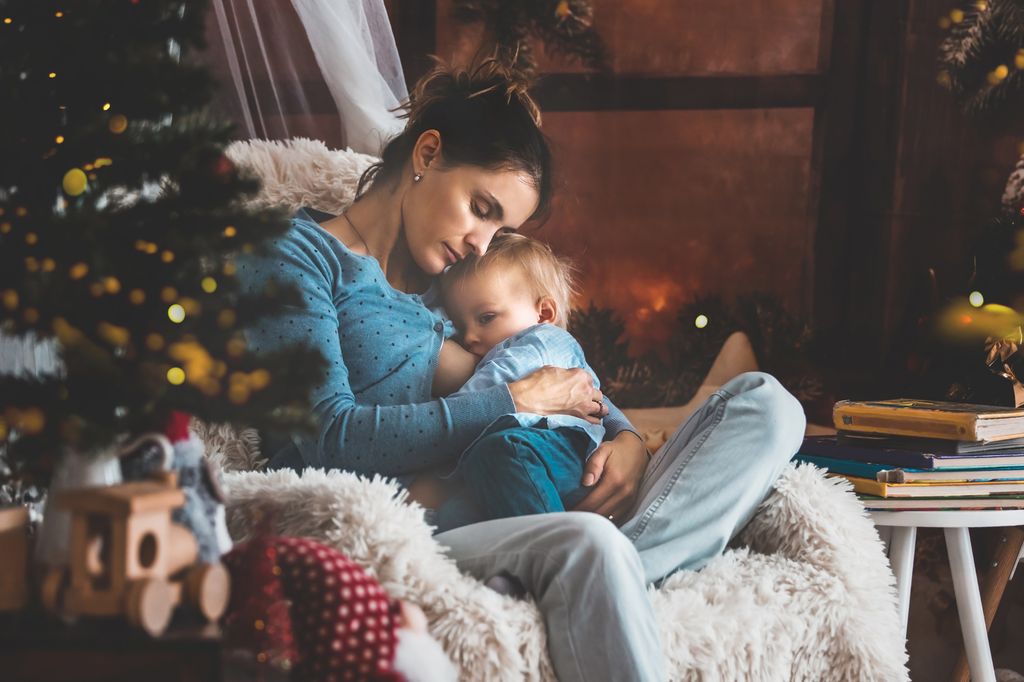 Madre dando el pecho a su hijo de noche en Navidad