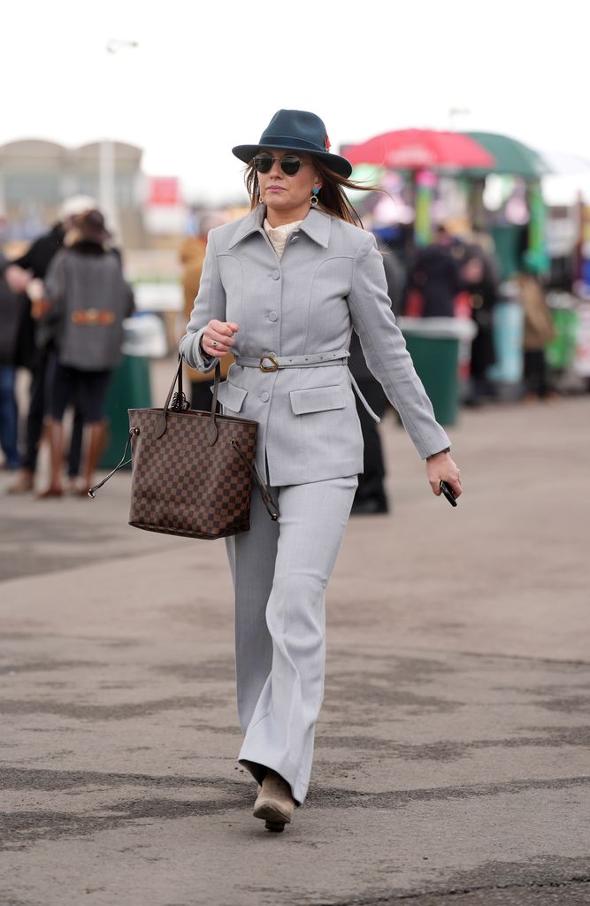 Look de invitada con traje y sombrero en el Cheltenham 2025