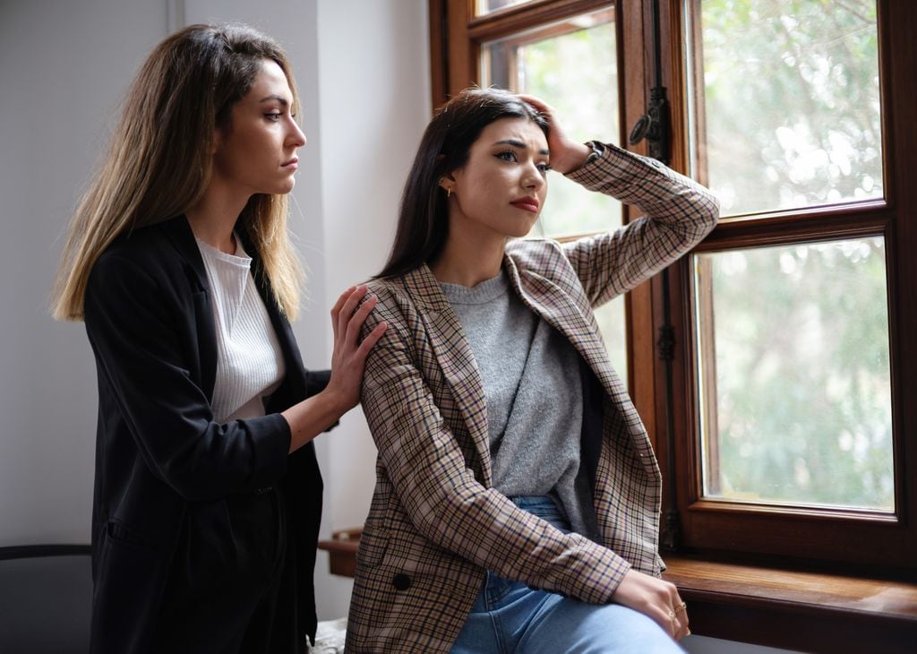 mujeres preocupadas junto a una ventana