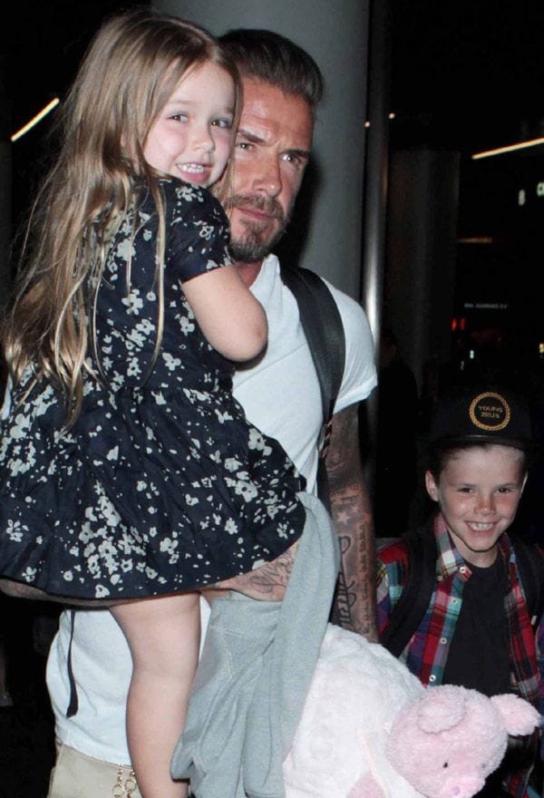 David Beckham con su hija Harper en brazos y dando la mano a su hijo Cruz en el aeropuerto de Los Ángeles. 
