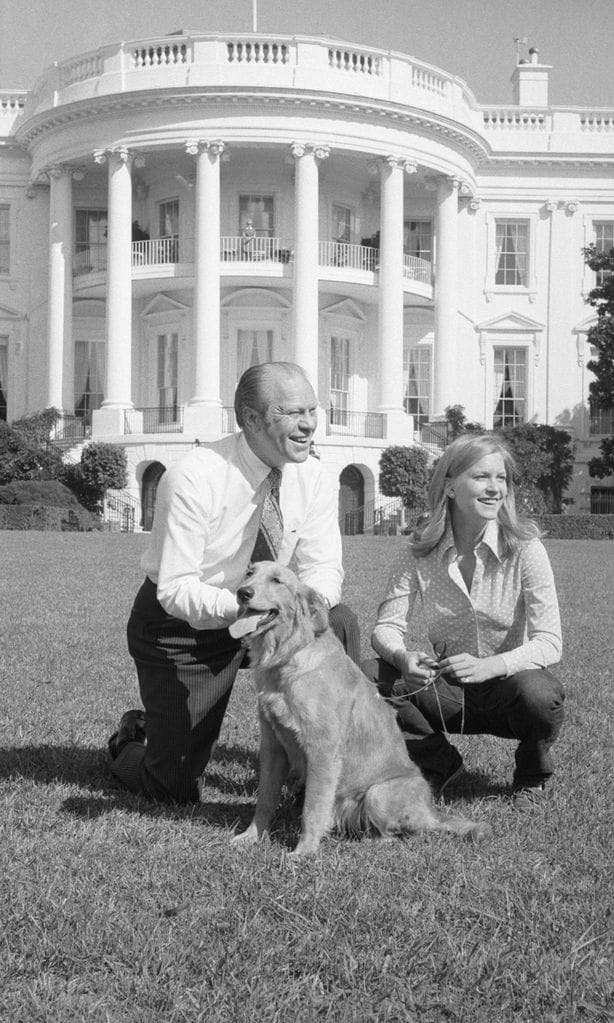 President Gerald Ford Stooping on Lawn with His Daughter and Dog