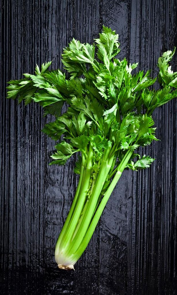 manojo de celery fresco sobre mesa de cocina