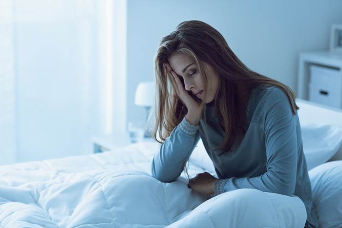 mujer con insomnio en la cama