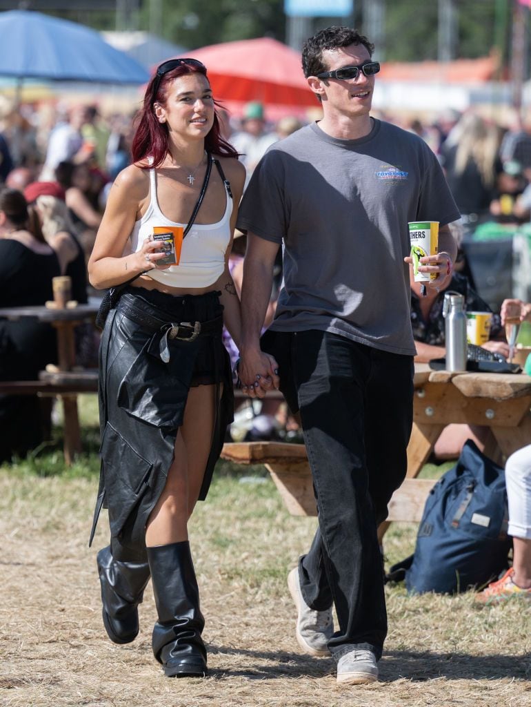 Dua Lipa lleva una falda y botas de piel con una clásica tank top y una bolsa 'crossbody'. Un set que se alínea con la estética de su presentación y su último álbum "radical optimism".  