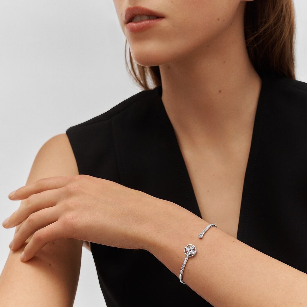 El brazalete Idylle Blossom Twist, fabricado en oro de 18 kt, se ha confeccionado exquisitamente para obtener un resultado muy flexible. Presenta un pavé de diamantes colocados de forma estratégica para realzar su deslumbrante brillo, y luce el inconfundible motivo Monogram Flower diseñado por primera vez por Georges-Louis Vuitton en 1896. 